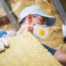Mineral Rock Wool Insulating Concept Photo. Worker with Piece of Insulating Wool in Hands.