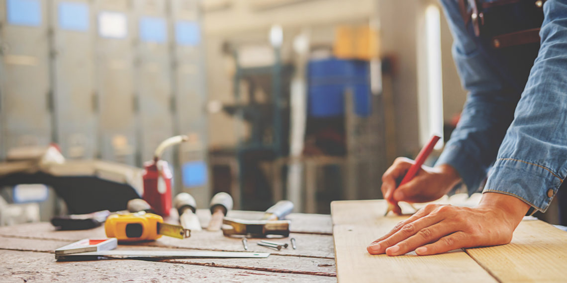 Carpenter working on woodworking machines in carpentry shop. woman works in a carpentry shop.