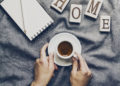Woman hands holding tasty coffee espresso in small cup on grey plaid. Home concept. Top View.
