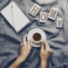 Woman hands holding tasty coffee espresso in small cup on grey plaid. Home concept. Top View.