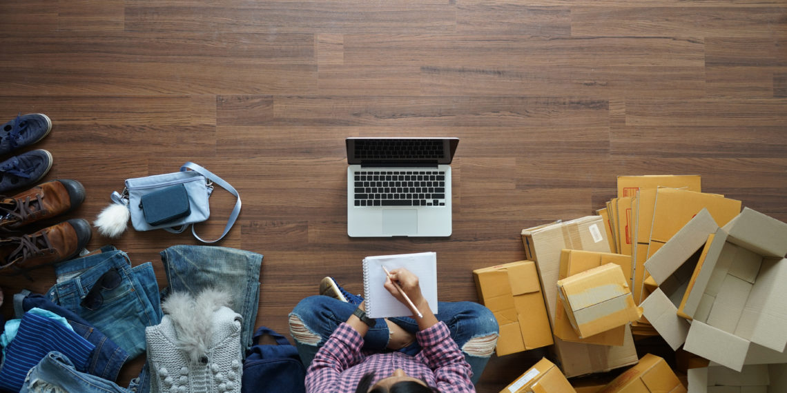 Top view of women write a notebook from home on wooden floor with postal parcel, Selling online ideas concept