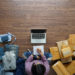 Top view of women write a notebook from home on wooden floor with postal parcel, Selling online ideas concept