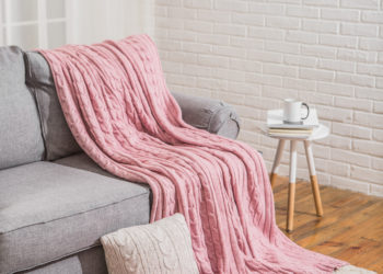 sofa with pink plaid in the interior near the window