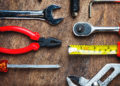 Set of construction tools on wooden board as wrench, hammer, pliers, socket wrench, spanner, tape measure, electric drill,safety glasses, screwdriver.