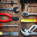 Set of construction tools on wooden board as wrench, hammer, pliers, socket wrench, spanner, tape measure, electric drill,safety glasses, screwdriver.