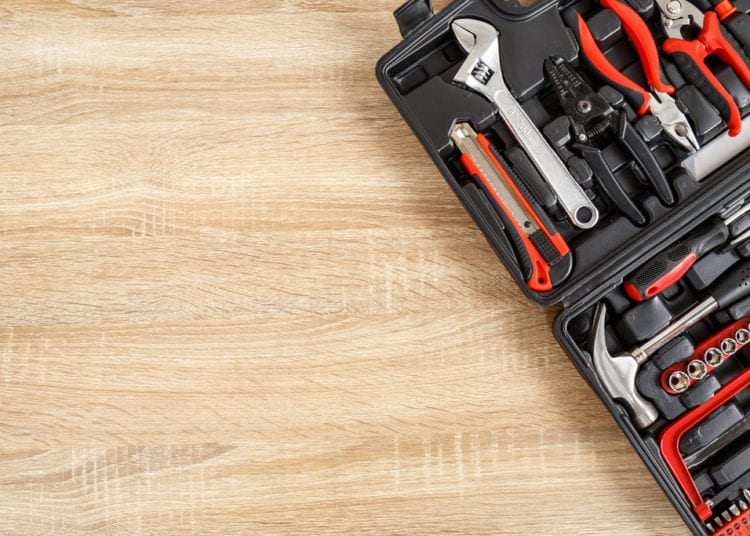 New square black tool box on wooden texture background. Top view