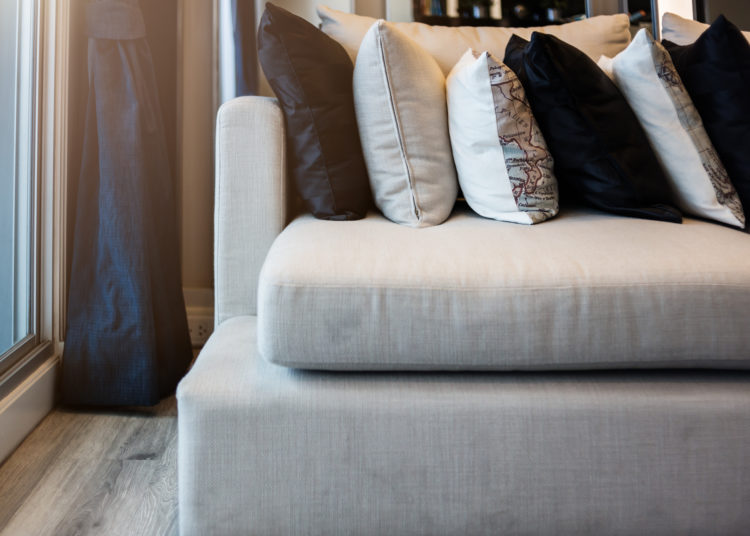 Bed maid-up with clean white pattern pillows and bed sheets in beauty room. Close-up. Lens flair in sunlight.