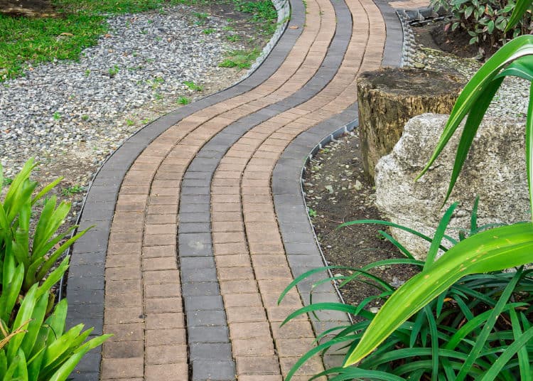 The Stone block walk path in the park with green grass background