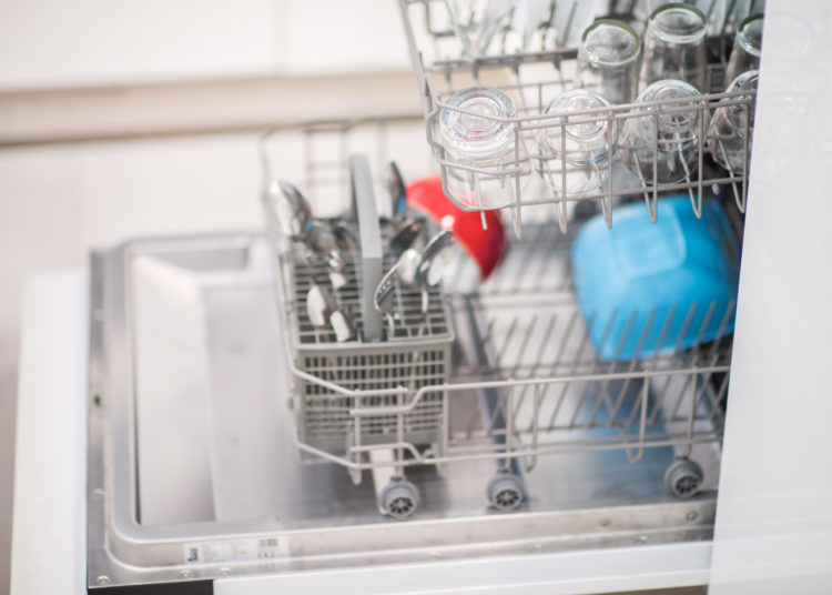 Open dishwasher with clean glass and dishes