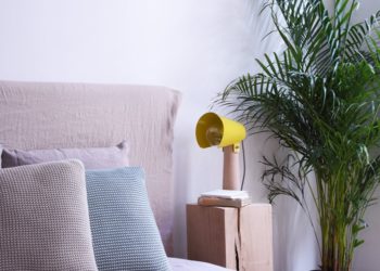Modern bedroom with yellow modern light on the cupboard