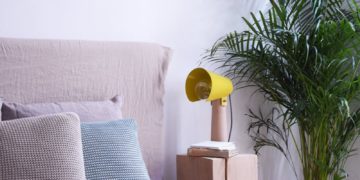 Modern bedroom with yellow modern light on the cupboard