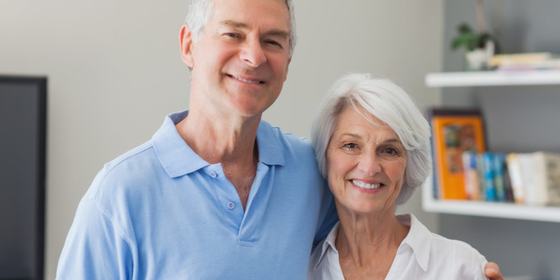 Portrait of an elderly couple embracing in living room