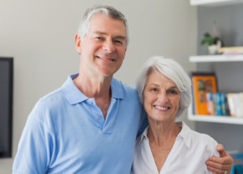 Portrait of an elderly couple embracing in living room