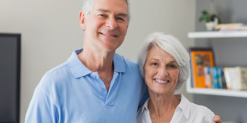 Portrait of an elderly couple embracing in living room