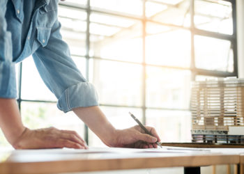 erson's engineer Hand Drawing Plan On Blue Print with architect equipment, Architects working at the table