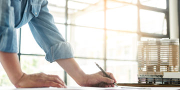 erson's engineer Hand Drawing Plan On Blue Print with architect equipment, Architects working at the table