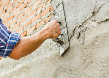 Builders are plastering the walls of the house with neatness. Have professional skills and high working experience. Concept of construction business.