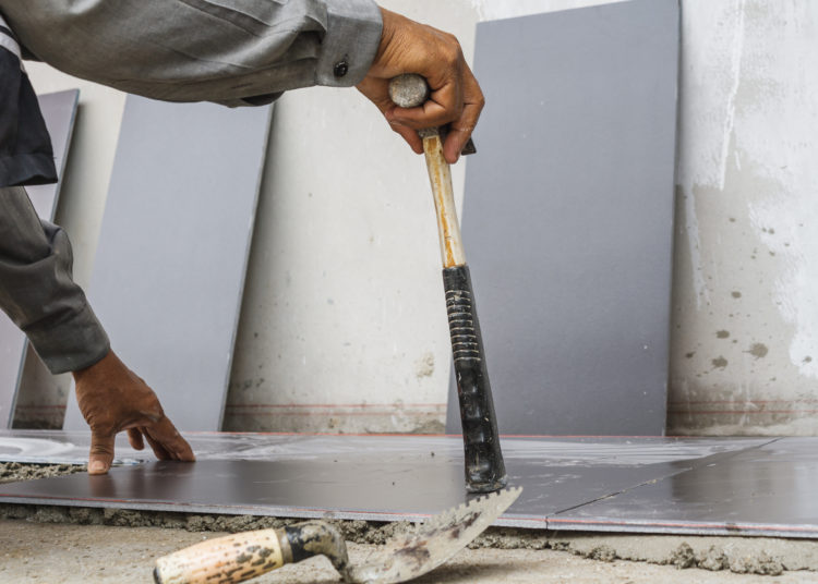 Worker working tiled in a construction site.