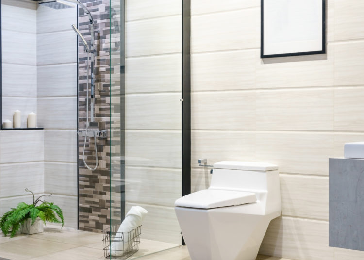 Modern spacious bathroom with bright tiles with toilet and sink. Side view