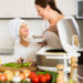 Happy 25-30 years old mother and little daughter using multicooker at kitchen
