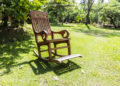 Empty rocking chair over grass at summer sunset
