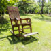 Empty rocking chair over grass at summer sunset
