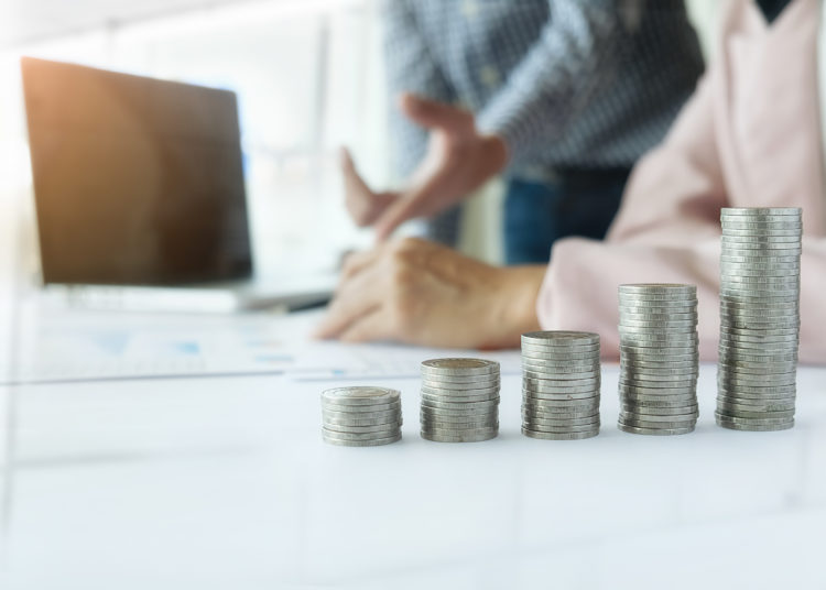 Business concept. Rows of coins for finance and banking concept with business man and woman. A metaphor of international financial consulting.