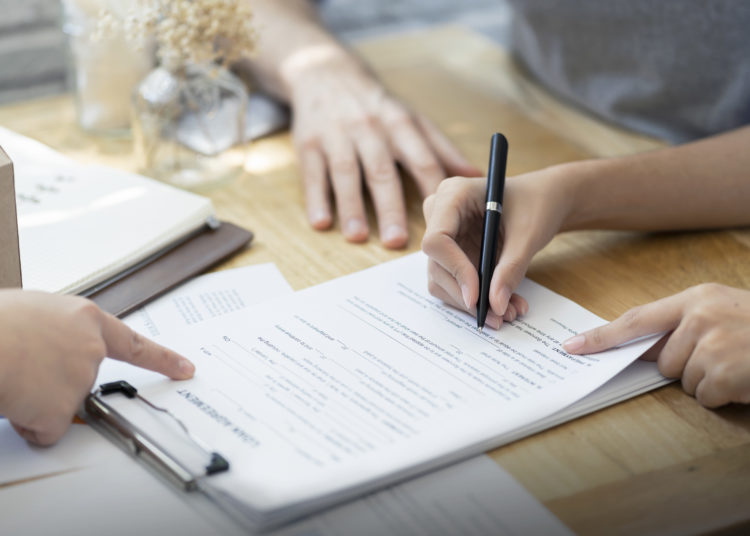 woman putting signature on document loan contract, real estate purchase, hands of woman sale represent point document to sign, contract deals success business.