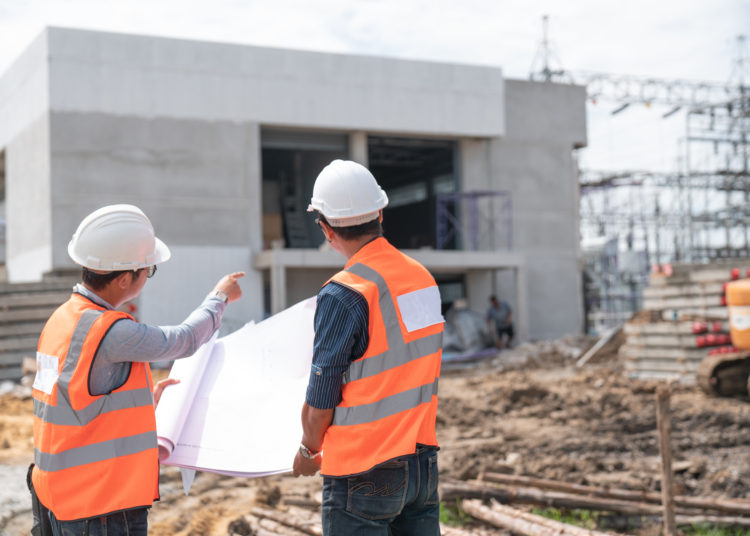 Construction engineers discussion with architects at construction site