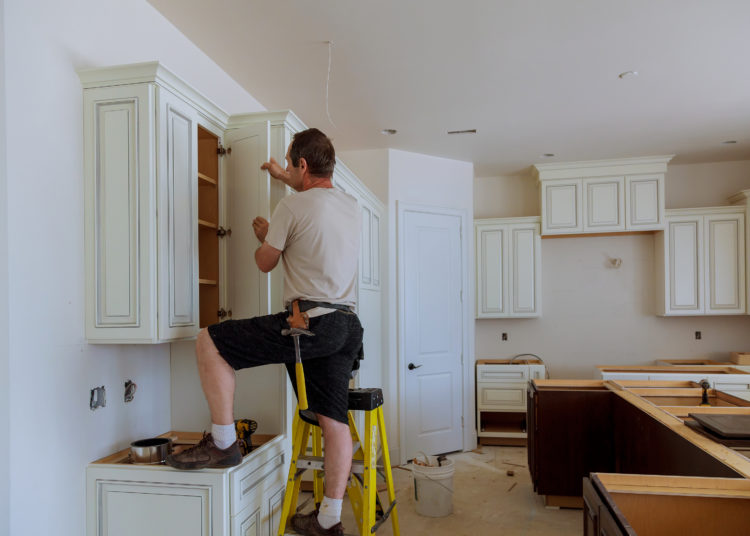 Man installing kitchen cabinets door installation of kitchen