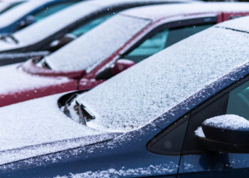 Snow covered cars in the parking, close up. Antifreeze was not used. Vehicles in snow. Winter time is coming. Bad weather conditions