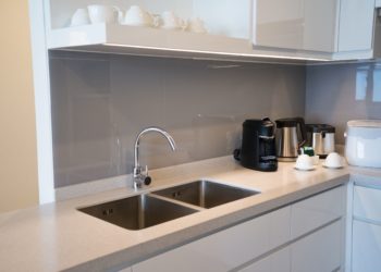 Minimalistic kitchen corner with appliances. Hotel room facilities including kettle, multicooker, coffeemaker, toaster, dish. City apartment concept