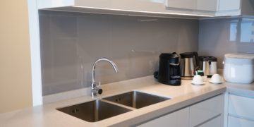 Minimalistic kitchen corner with appliances. Hotel room facilities including kettle, multicooker, coffeemaker, toaster, dish. City apartment concept