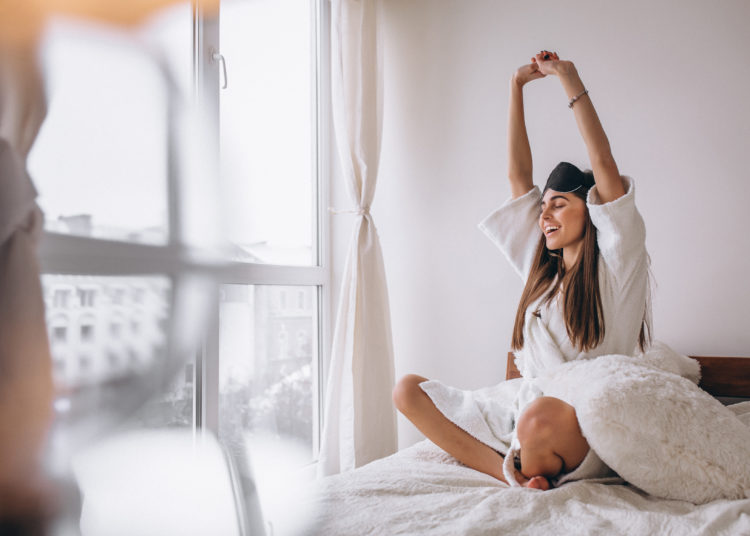 Woman in bed wearing sleeping mask