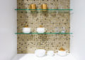 kitchen ceramic and white mug on a glass shelves in a white cabinet with colorful mosaic background.