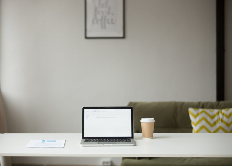 Working table with laptop, coffee and documents for daily online distance work or education in home office interior, freelancer desk with computer in modern living room, comfortable workplace concept