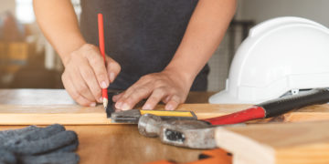 Safety hard hat on the table and worker as background.
