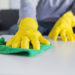 people, housework and housekeeping concept - close up of man hands cleaning table with cloth at home