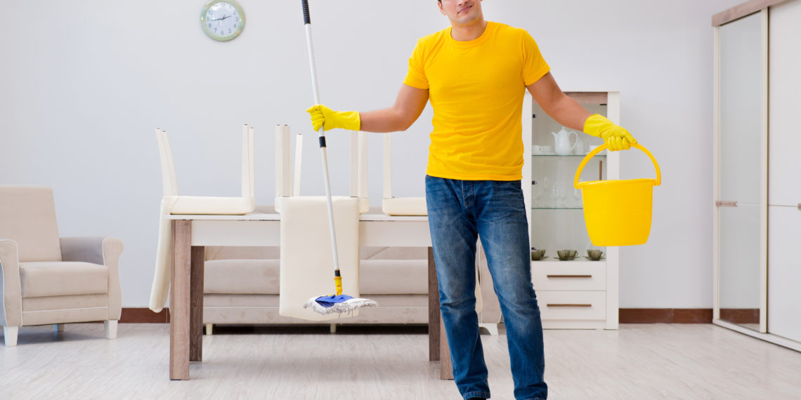 Man cleaning the house helping his wife