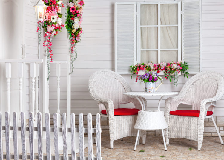 White country house in Provence style decorated with flowers. The summer residence and a place to relax with wicker furniture.