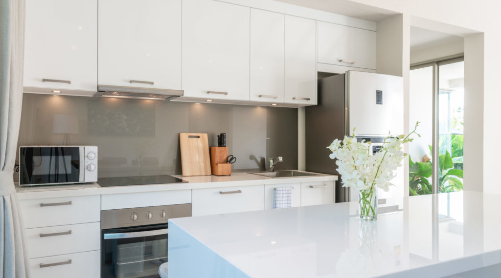 Luxury interior design in living room of pool villas. Airy and bright space with high raised ceiling and kitchen area with dining table