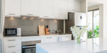 Luxury interior design in living room of pool villas. Airy and bright space with high raised ceiling and kitchen area with dining table