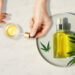 Pipette with CBD cosmetic oil in female hands on a table background with a bottle of cannabis oil and hemp leaves, marijuana