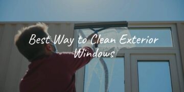 A person cleaning exterior windows with a squeegee, sunny day, clear blue sky, realistic.