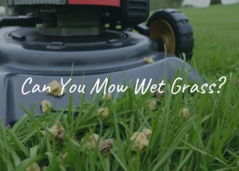 A lawnmower struggling to cut wet grass, clumps of grass sticking to the blades, damp green lawn, cloudy sky, realistic.