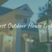 Stylish outdoor house lights illuminating a cozy front porch at dusk, warm white glow, modern lantern design, blended with natural greenery, realistic lighting effect.